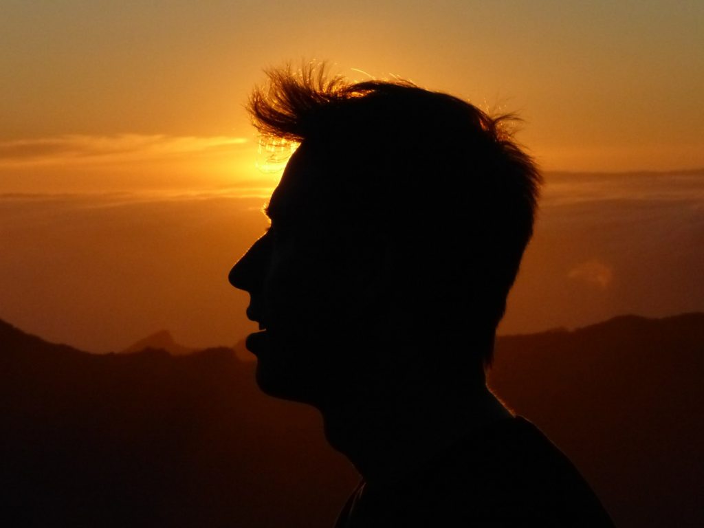 Prepare to Be Blown Away_Elisha_backlit profile of man at sunset, hair blowing, deep in thought