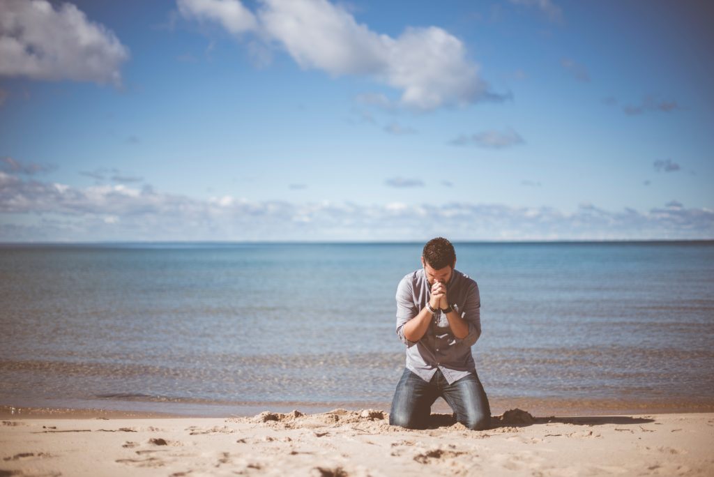 When God Reveals Deep and Hidden Things_man kneeling on seashore, praying